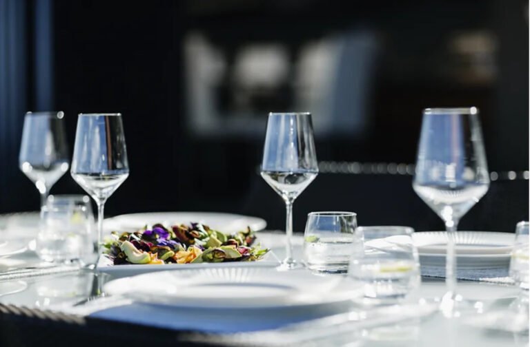 Food photo showing food and water glasses set on dinning table. Used as a featured image for the article Top Restaurants in Huntsville AL