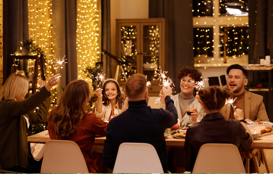 A lively dinner party gathering with family and friends around a beautifully set table, enjoying sparklers, conversation, and a warm ambiance. Learn tips on how to host a diner party for a memorable experience.