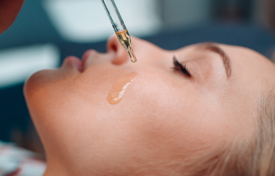 Close-up of a woman receiving facial oil application with a dropper for smooth, radiant skin, showcasing the nourishing benefits of using the best face oils.