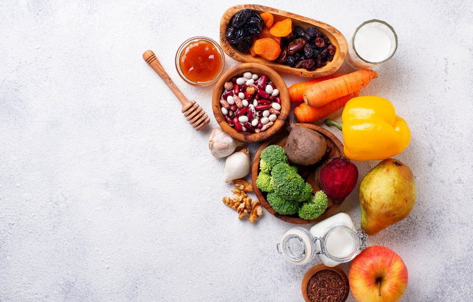 An assortment of gut-healing foods including colorful vegetables, fruits, nuts, seeds, and fermented items like yogurt, promoting a diet for healing leaky gut.