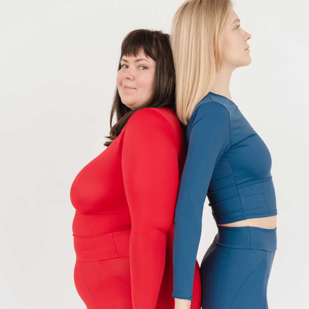 Image of two individuals stand back-to-back. The person on the left wears a red top and pants, while the person on the right is dressed in a blue long-sleeve top and pants showing dress for your body shape.