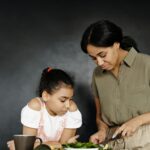 Image of a mother and daughter bonding over cooking together in a warm and intimate kitchen setting. Image used for the article Can a Stay-at-Home Mom Collect Social Security Disability?