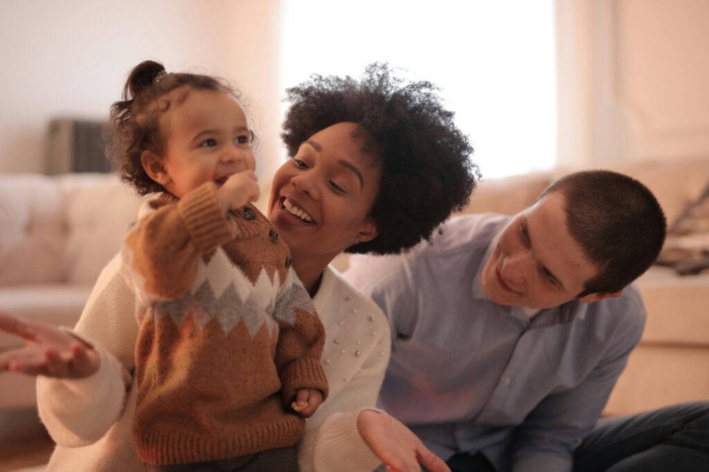 Mother and father smiling because they enjoy spending time with their daughter