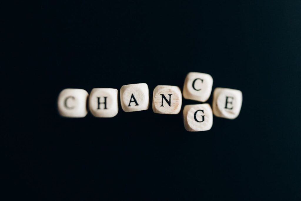 Image of wooden blocks spelling 'CHANGE' against a black background with scattered positioning. Used for the article How to Rediscover Yourself as a Mom