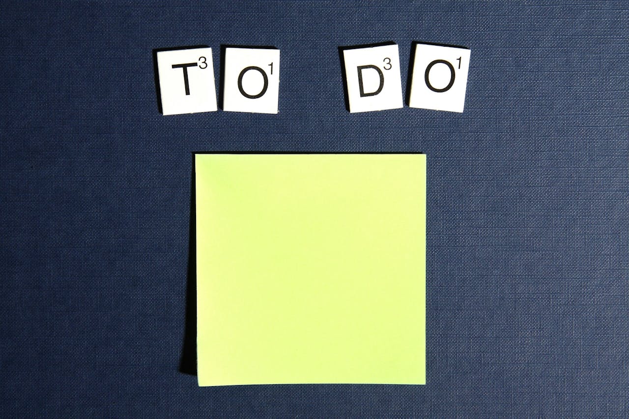 How Can a Mother Manage Work-Life Balance? Image of a blank yellow sticky note under TO DO, spelled with letter tiles on a dark blue textured background, showing how working moms balance job and kids.