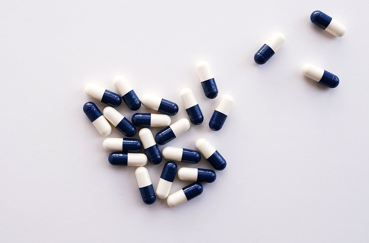 Why Mornings Are Challenging if You Have Depression? Image of a group of blue and white capsules scattered on a white surface.