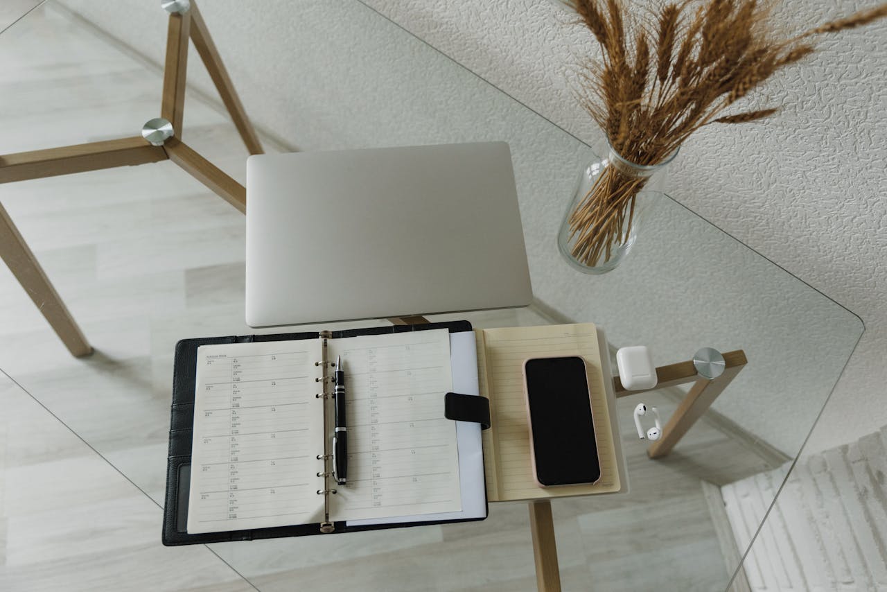 How Women Working in Demanding Careers Can Make Time for Physical Wellness? Image of a phone and a record on a table showing the schedule of work, representing how women working in demanding careers can make Time for physical wellness.