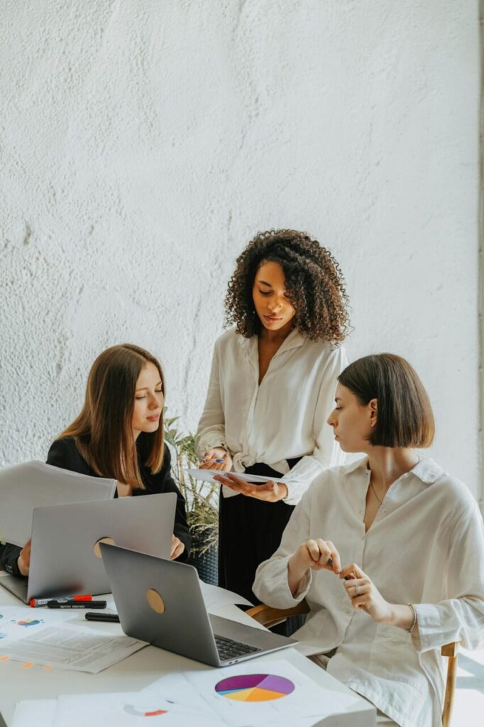 image of three women working on a project in the office.